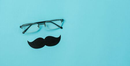 Table top view Happy Fathers day holiday background concept.Flat lay  photo booth prop the eye glasses and mustache on modern rustic blue paper with copy space for creative design world.vintage style.の写真素材