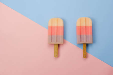 Table top view aerial image of sign or food of summer season holiday background concept.Flat lay of pastel sweet ice cream on modern rustic pink paper backdrop.Minimalism and copy space design word.の写真素材