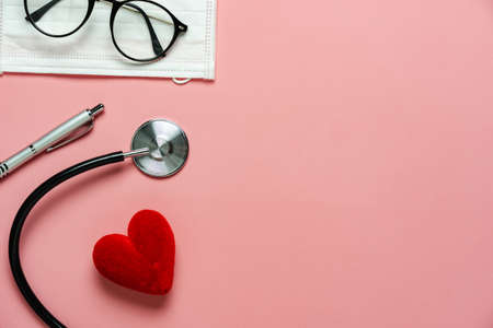 Flat lay aerial of accessories healthcare medical background concept.Free space for mock up  template.Difference objects on modern rustic pink paper.An idea for essential tools doctor in hospital.の写真素材