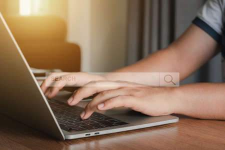 Hand businessman using laptop at home office workplace. Blank search bar webpage with browser of...