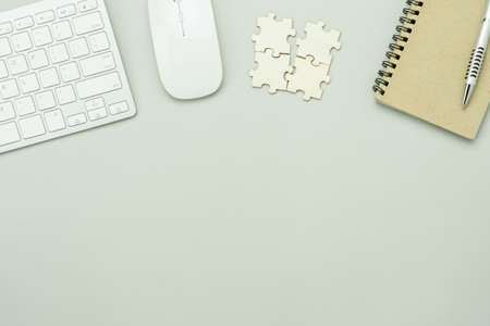 Top view essential accessories of working on table at office workplace. Flat lay pen keyboard mouse device notebook puzzle piece .copy space. Business and finance idea objects concept background.の写真素材