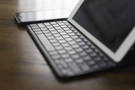 Tablet with Cell phone On Brown Tableの写真素材