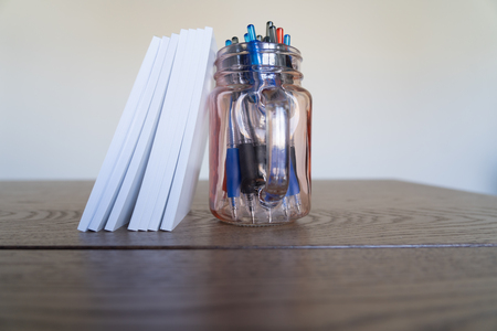 notepads with a jar of pens as a bookendの写真素材