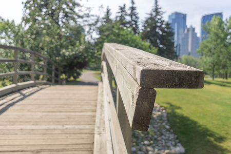 Small Bridge on footpath in city park with city skyline in backgroundの写真素材