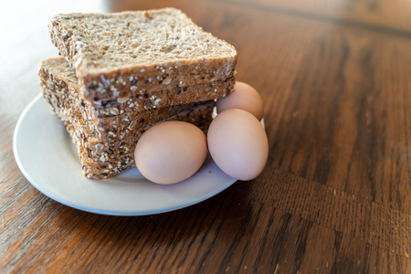 Brown fresh Eggs and Slices of Whole grain bread on white plate