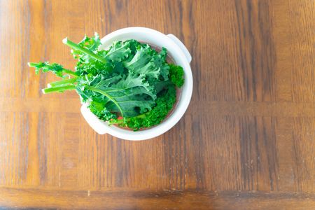 Bunch organic fresh of kale in plastic bowl on tableの写真素材