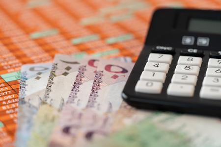 Qatar Riyal Bank Notes on spreadsheet report background With Calculatorの写真素材