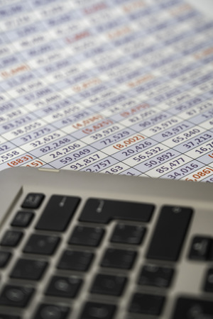 laptop keyboard with spreadsheet in the background