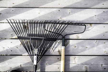 Garden Rakes on wood decking in a residential homeの写真素材