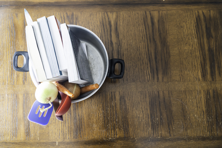 Books in pot ready to be cooked - Fraud Concept