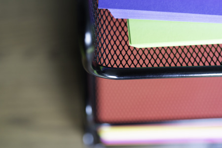 stack of documents on brightly colored paper on stacked tray on office table