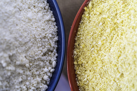 Red and Yellow Garri in bowls on Table topの写真素材