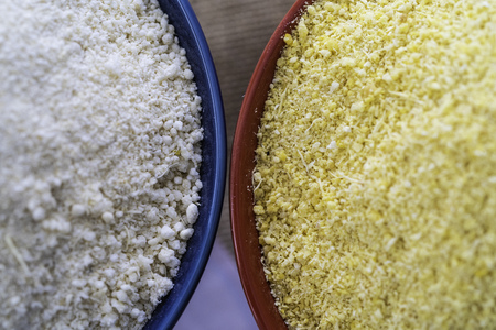 Red and Yellow Garri in bowls on Table topの写真素材