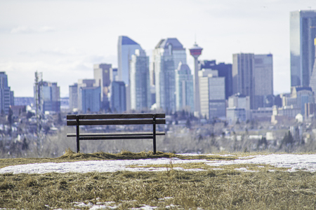Park bench on Hill with City Skyline behind itの写真素材