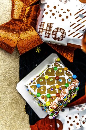 Gingerbread house roof under christmas tree with presentsの写真素材