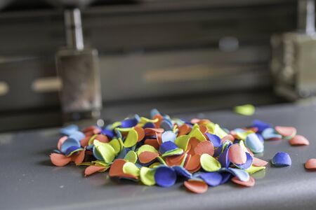 Paper Chads produced by punching holes in a sheets of colored paper