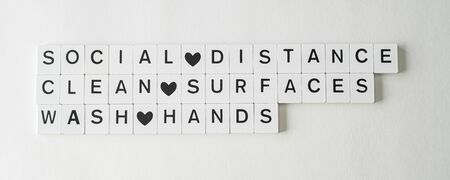 Leter tiles showing health rules to keep Social distance, wash hands and clean surfaces