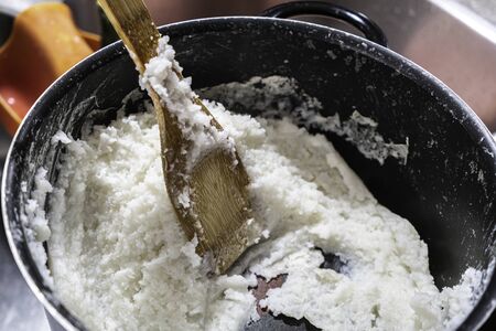 Nigerian Tuwo Shinkafa prepared in a pot with a wooden Spatulaの写真素材