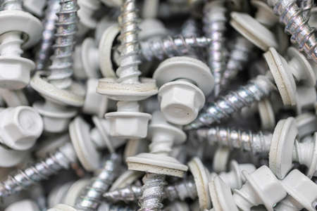 Pile of Grey roofing screws in a hardware store
