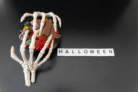 Bowl of Halloween Candy covered with skeleton claws - Halloween Conceptの写真素材