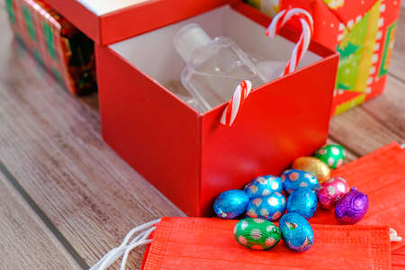 Christmas gift wrapped presents with face masks and hand sanitizer bottles