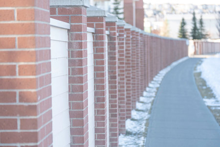 wood wall beside a walkway pavement in cityの写真素材