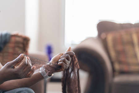 African American Nigerian woman preparing her hair for braidingの写真素材