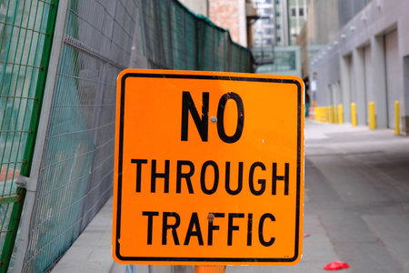 No through traffic sign in front of Alleyway behind buildingsの写真素材