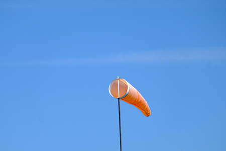 orange wind sock flying in the wind to show wind directionの写真素材