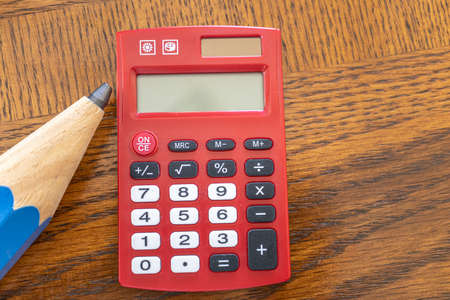 Giant Pencil with Red Pocket Calculator on office tableの写真素材