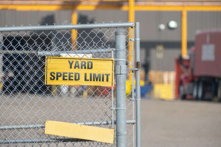 Safety sign on factory fence in industrial areaの写真素材
