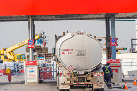 9 October 2021 - Calgary Alberta Canada - Petrol tanker truck delivering gas at filling stationのeditorial素材