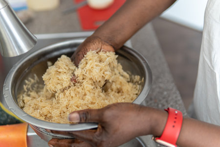 African American Nigerian woman washing rice before cooking