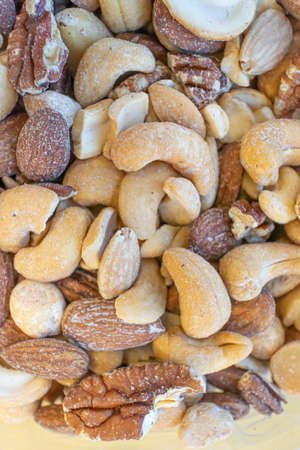 Assorted pile of peanuts, cashew and walnuts shot from above