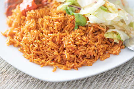 Nigerian African Jellof rice served with vegetable Saladの写真素材