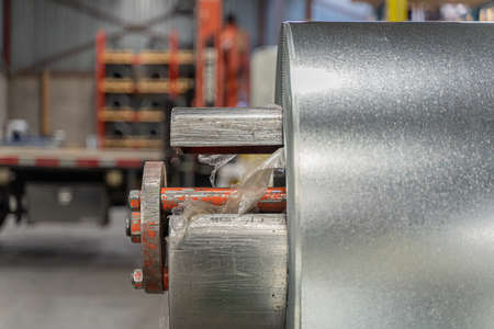 roll of silver metal steel coil in a metal roofing factoryの写真素材