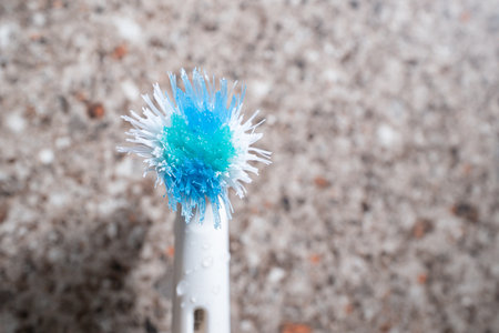 old worn electrric toothbrush head in bathroom sink
