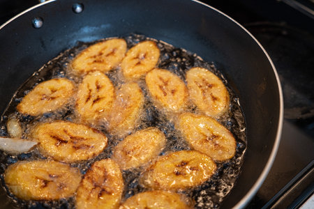 Deep frying plantain a frying pan in Kitchenの写真素材