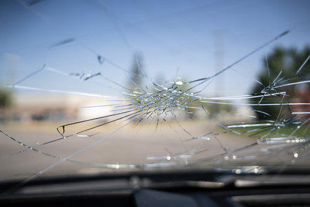 Smashed vehicle windscreen with massive hailstorm damageの写真素材