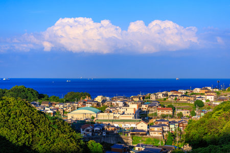 Afternoon sun hits small coastal village as clouds billow in distanceの写真素材