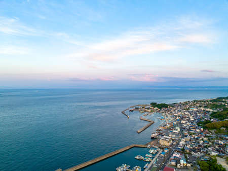Aerial view of breakwaters protecting small coastal village before sunset