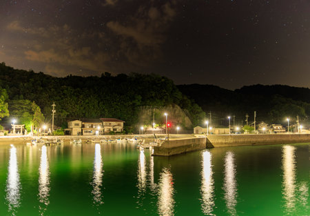 Quiet harbor in small coastal village under starry night skyの写真素材