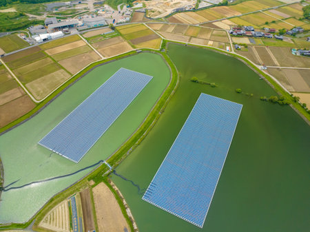 Solar panels float on water in irrigation reservoir by rice fields and farms