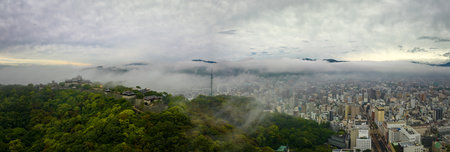 Matsuyama, Japan - June 11, 2023: Early morning fog over historic castle and modern cityのeditorial素材