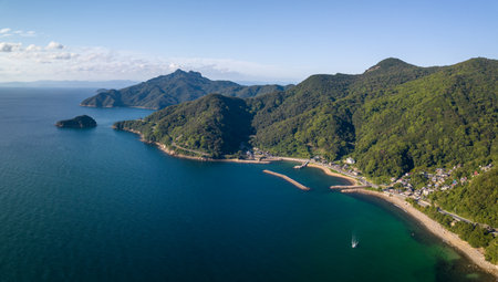 Aerial view of small coastal beach town by mountains on Shodo Islandの写真素材