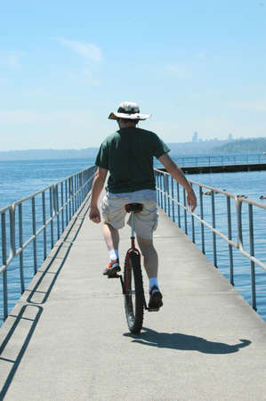 Unicyclist riding on the pier.の写真素材