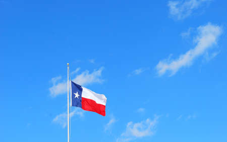 Texas flag flying high in the sky.の写真素材