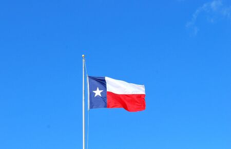 Texas flag flying high in the sky.の写真素材
