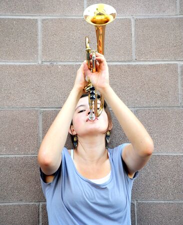 Female trumpet player blowing her horn.