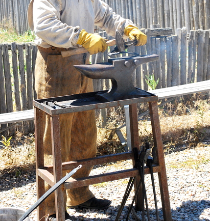 Farrier working on a horseshoe outside.の写真素材